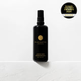 Black bottle of Wildcrafted Organics on a white background with an award badge.