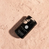 Black container with 'Wildcrafted Organics' branding on a textured beige surface