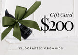 Gift card for $200 with a bottle and green bow on a white background, featuring Wildcrafted Organics branding.