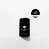 Black container labeled 'Wildcrafted Organics' on a white background with an award badge above it.
