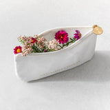 White pouch with flowers on a light gray background
